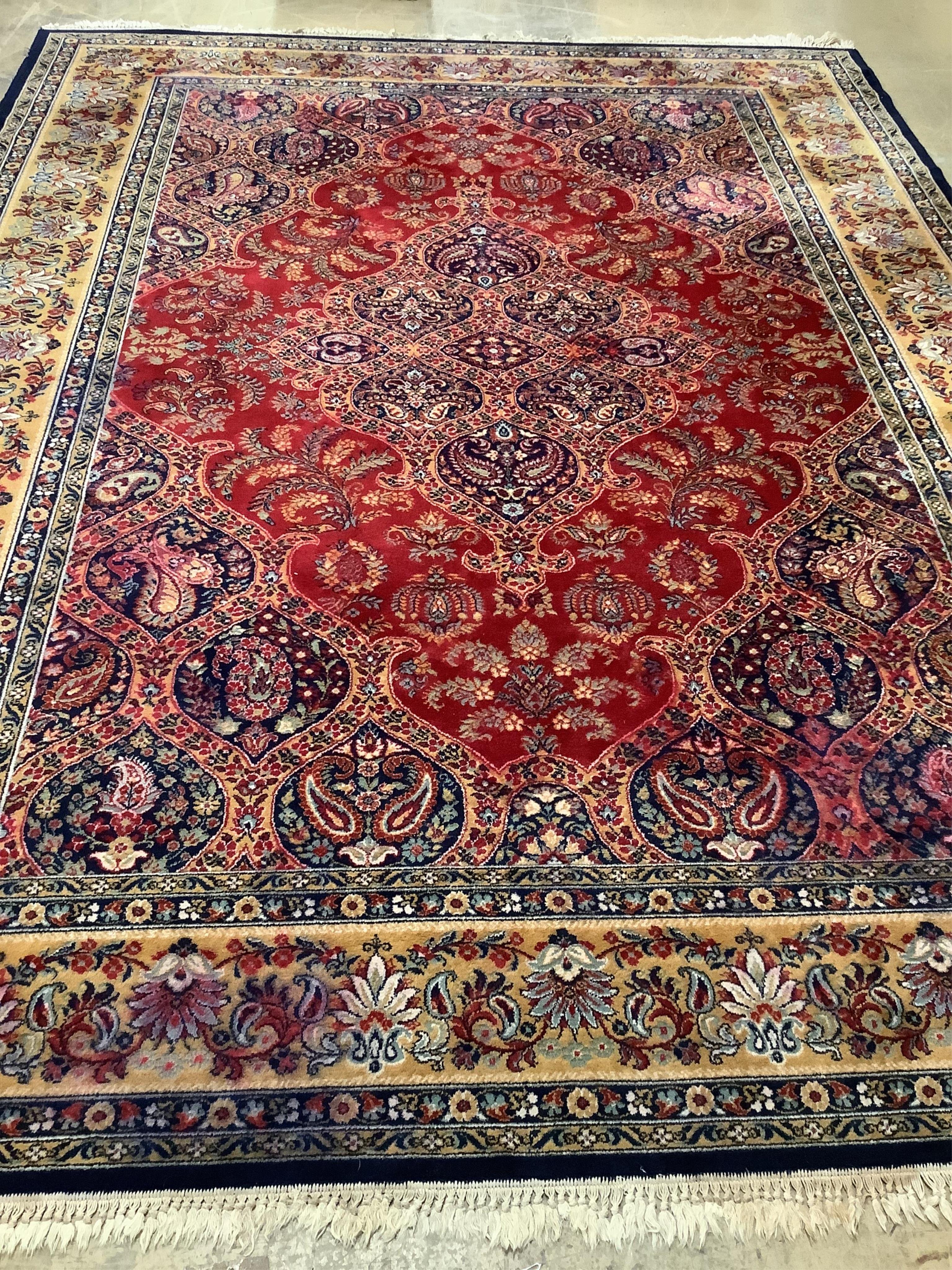 A Kashmiri style red ground carpet, 360 x 270cm